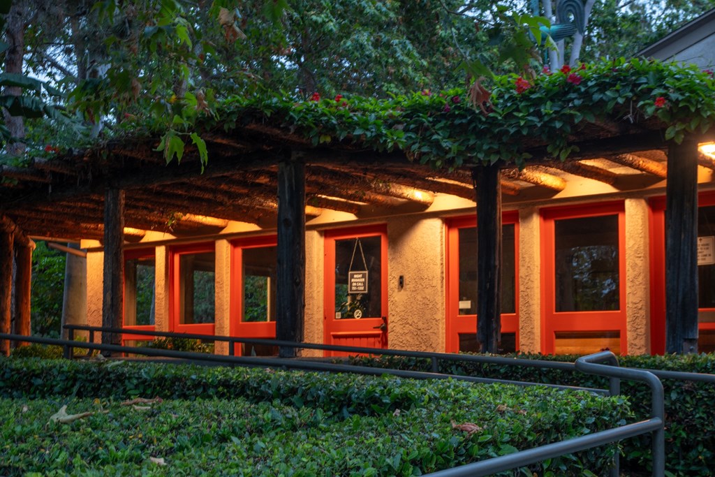 the front of a building with red doors and a covered porch