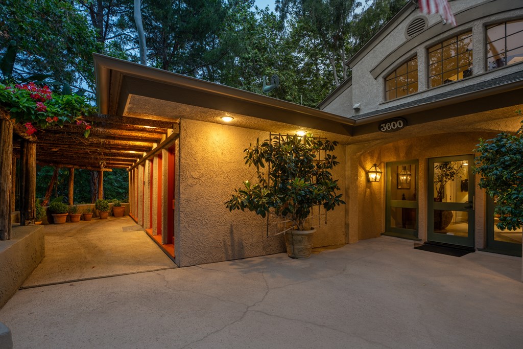 the front of a building with a patio and a plant