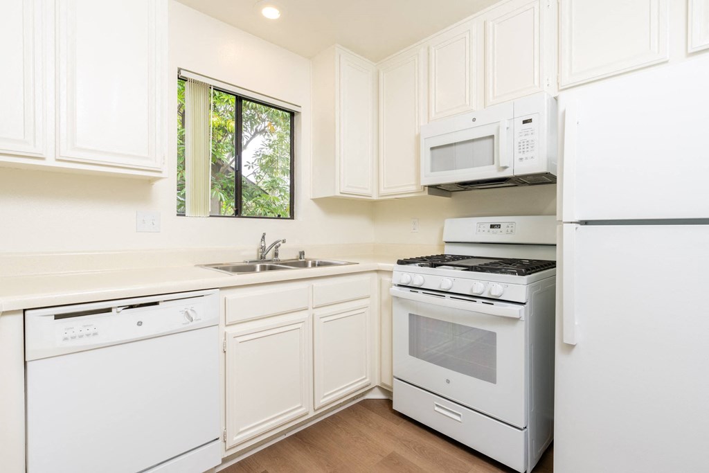 a white kitchen with white appliances and white cabinets