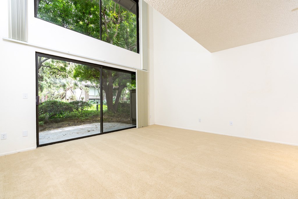 an empty living room with a large window and