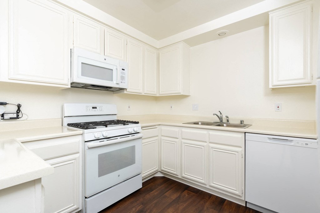 a kitchen with white appliances and white cabinets