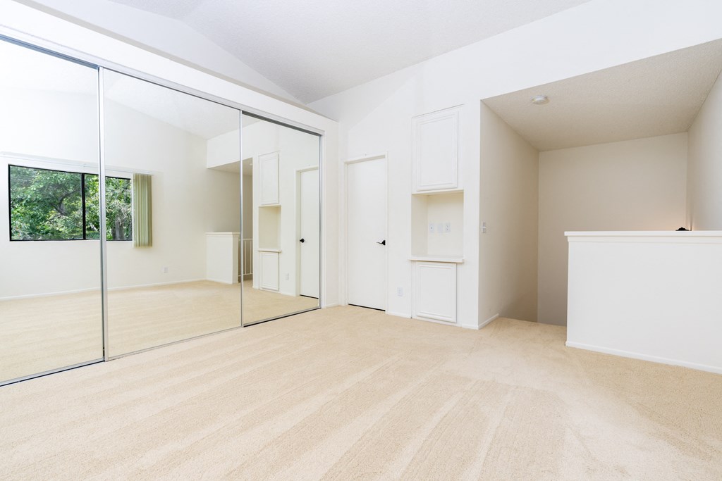 an empty room with a mirror and a closet