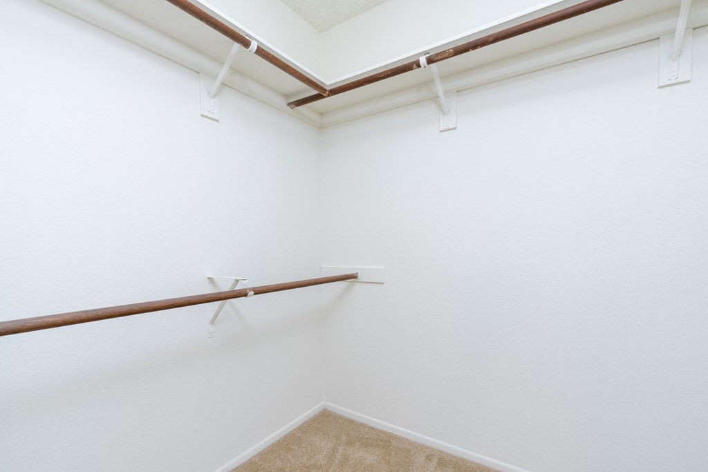 an empty room with white walls and a rail in the corner