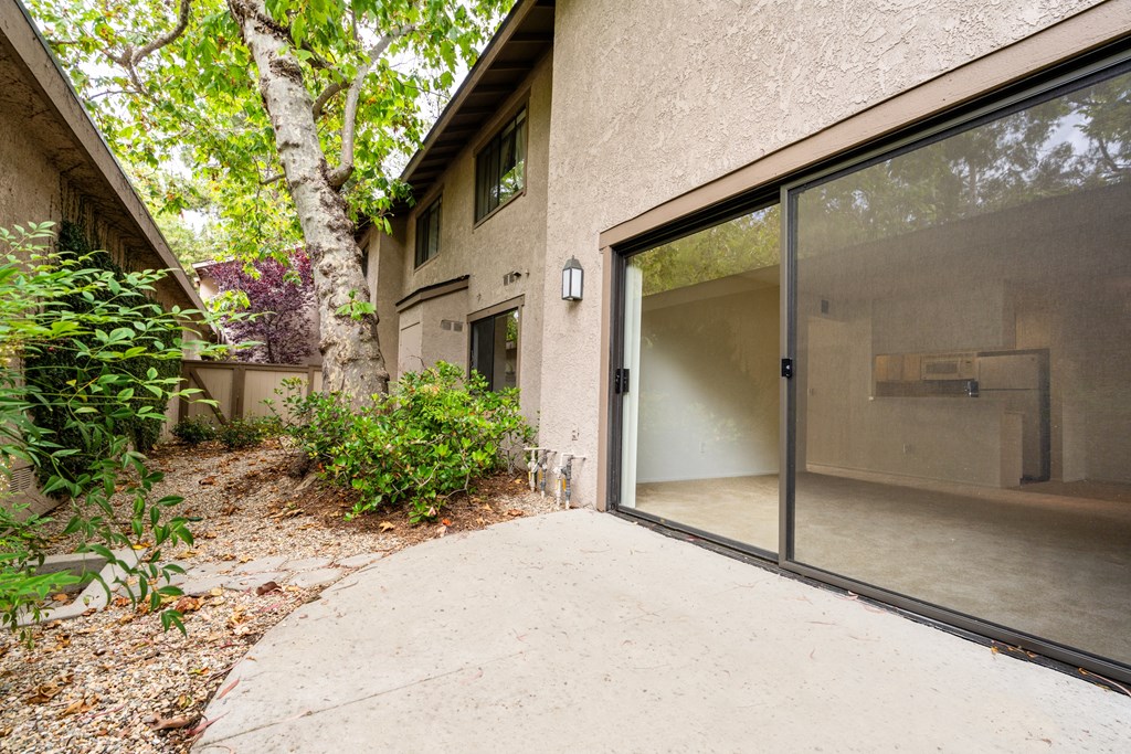 the entrance to a house with glass doors and a concrete walkway