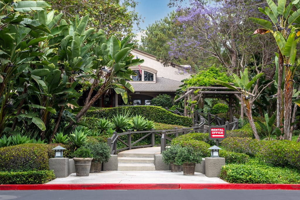 a house with a staircase and a sign in front of it
