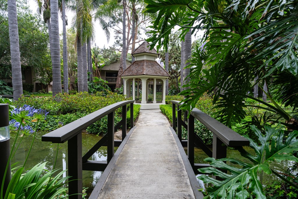 a bridge leading to a garden with a gazebo