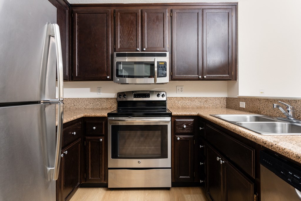 a kitchen with stainless steel appliances and brown cabinets