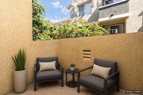 Two chairs and a table are placed on a patio.