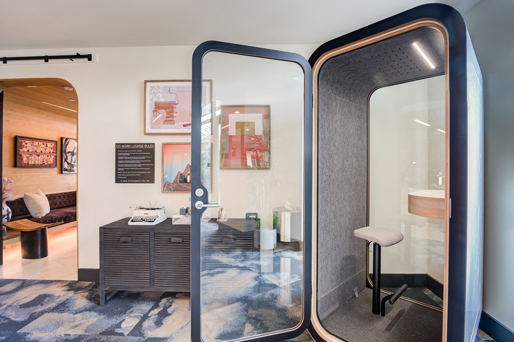 a room with a glass door and a desk with a stool in it