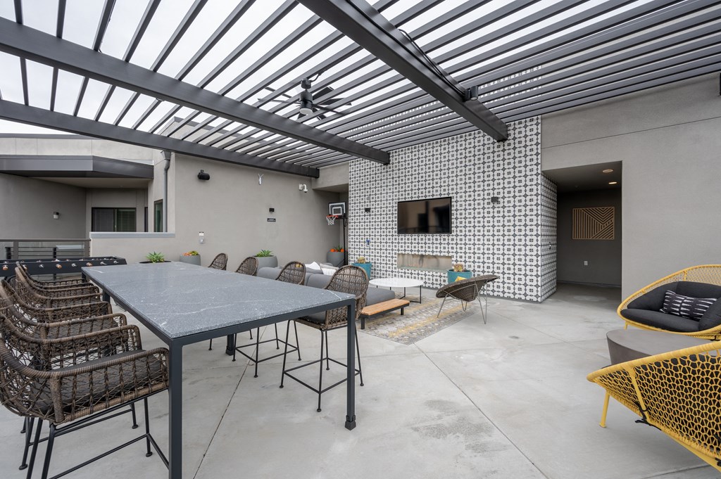 a patio with a table and chairs and a television on the wall