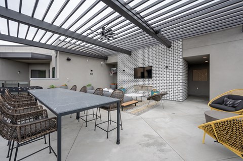 a patio with a table and chairs and a television on the wall
