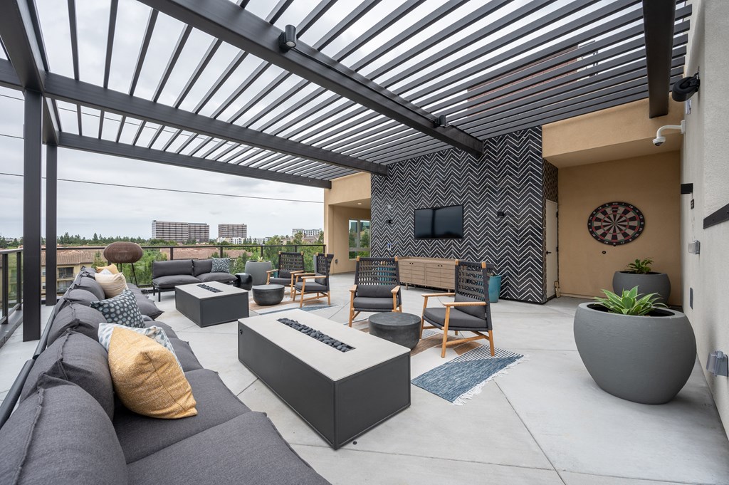 a patio with couches and chairs and a tv
