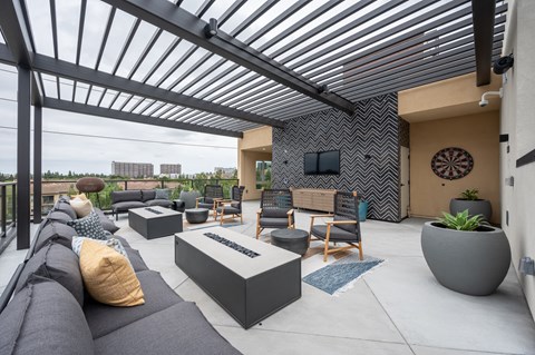 a patio with couches and chairs and a tv