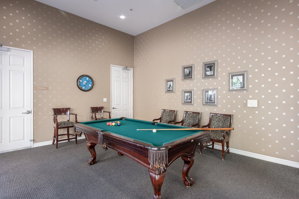a game room with a pool table and chairs