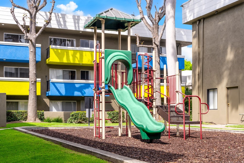 a playground in front of a building with a slide
