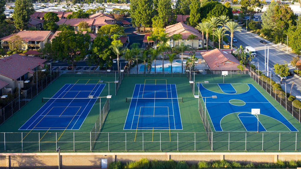 A tennis court surrounded by a fence and trees.