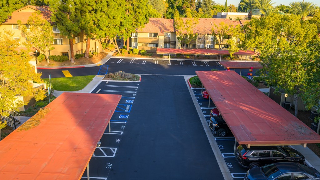 A parking lot with cars parked under orange canopies.
