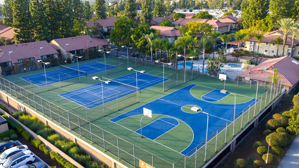 A tennis court surrounded by a fence and trees.