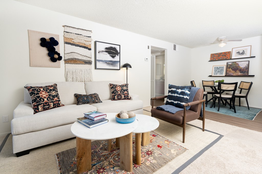 A living room with a white couch, a coffee table, and a chair.