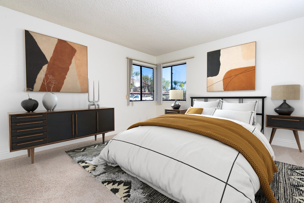A bedroom with a large bed and two abstract paintings on the wall.