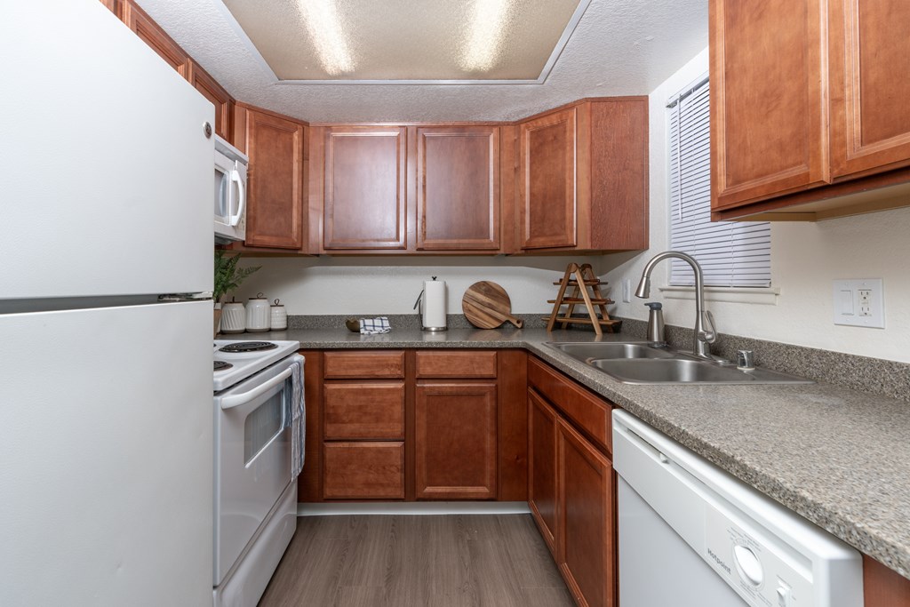 A kitchen with wooden cabinets and a white refrigerator.