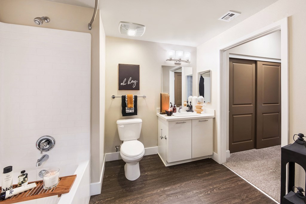 a bathroom with a toilet sink and shower and a mirror