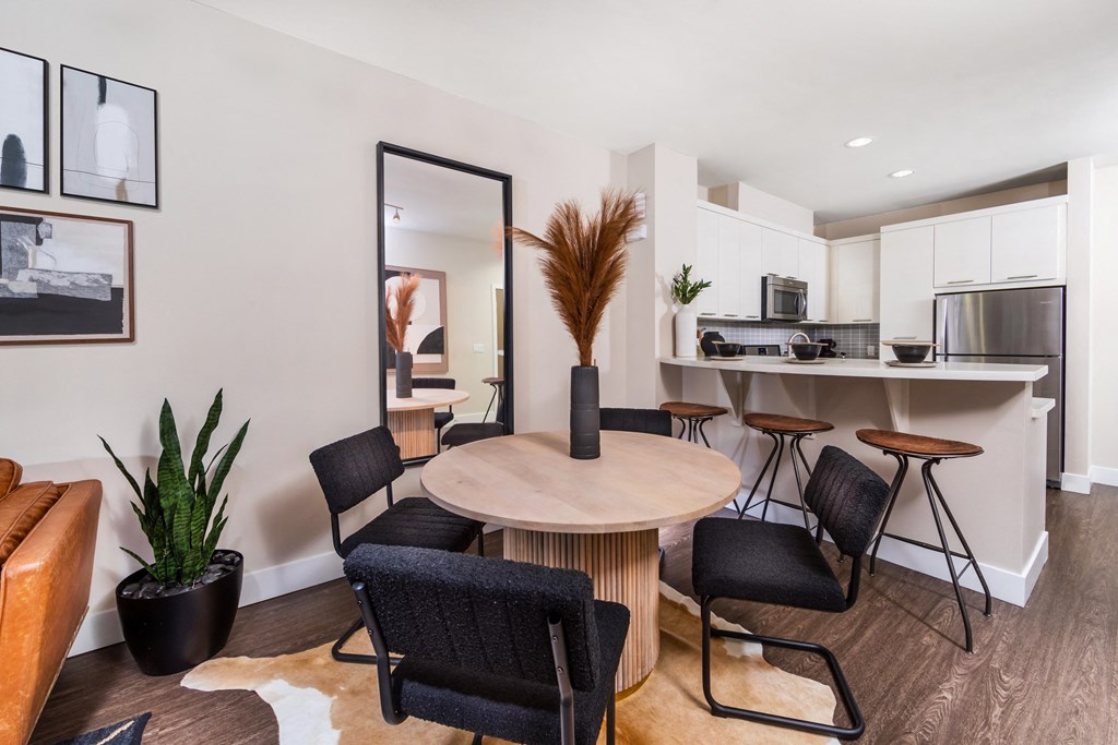 a living room with a table and chairs and a kitchen