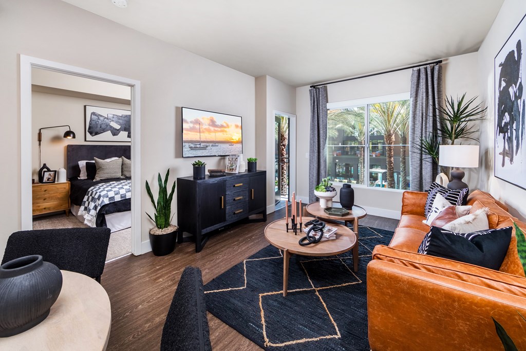 an open living room with a large window and a bedroom