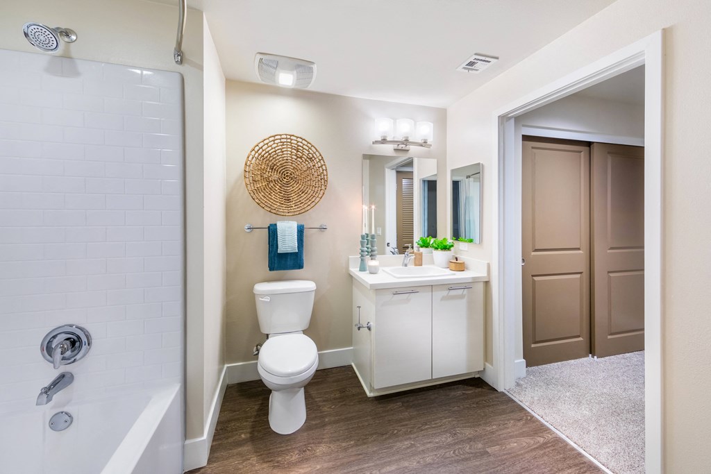 a bathroom with a toilet sink and shower and a mirror