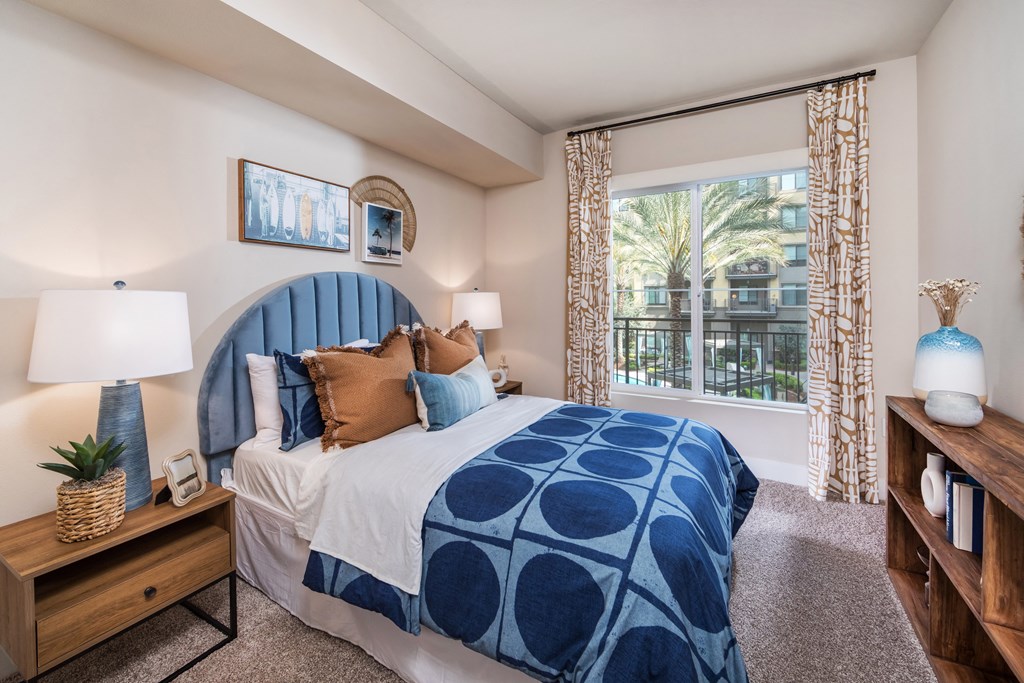 a bedroom with a blue and white bed and a window