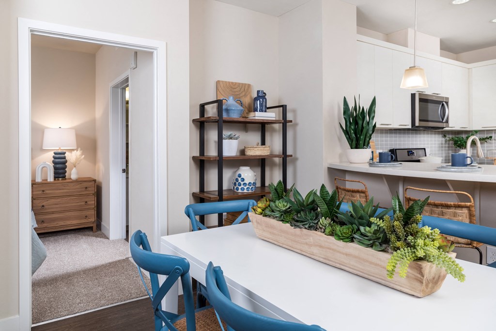 a dining room table with blue chairs and a succulent centerpiece