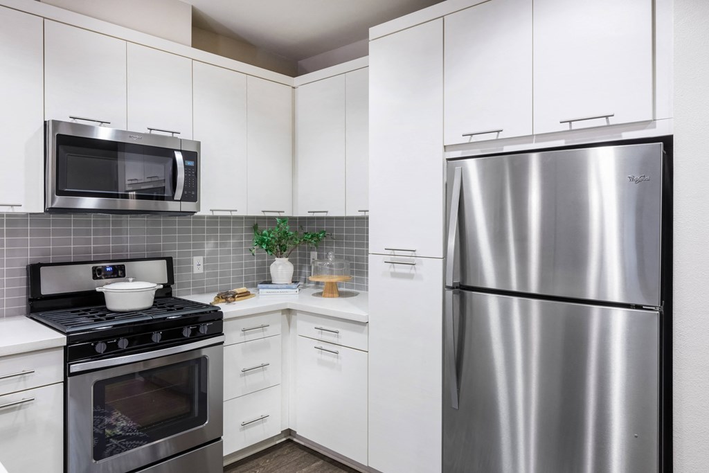 a kitchen with stainless steel appliances and white cabinets