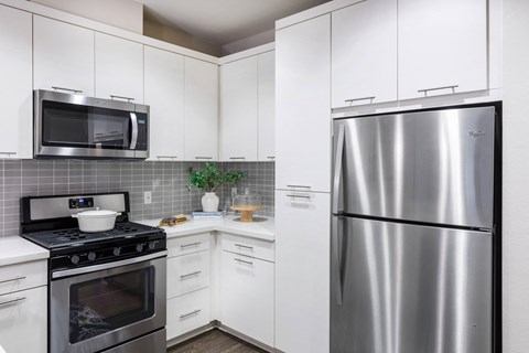 a kitchen with stainless steel appliances and white cabinets