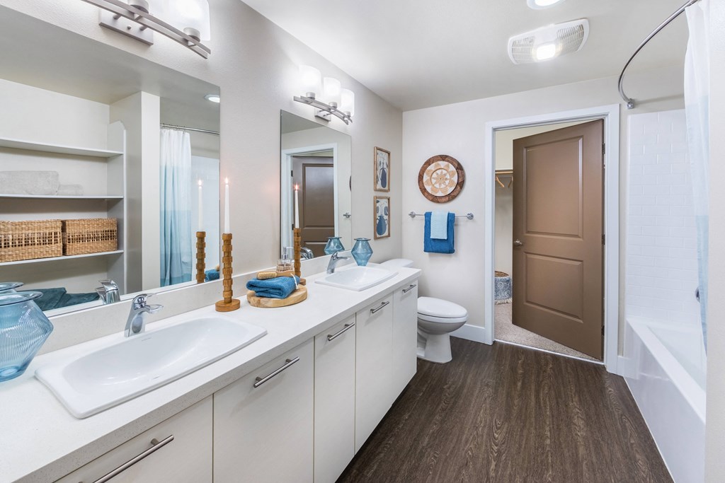 a bathroom with two sinks and a toilet and a mirror