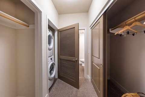 a small bathroom with a washer and dryer and a closet with a door