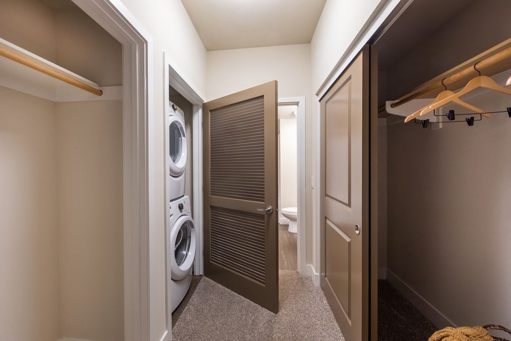 a small bathroom with a washer and dryer and a closet with a door