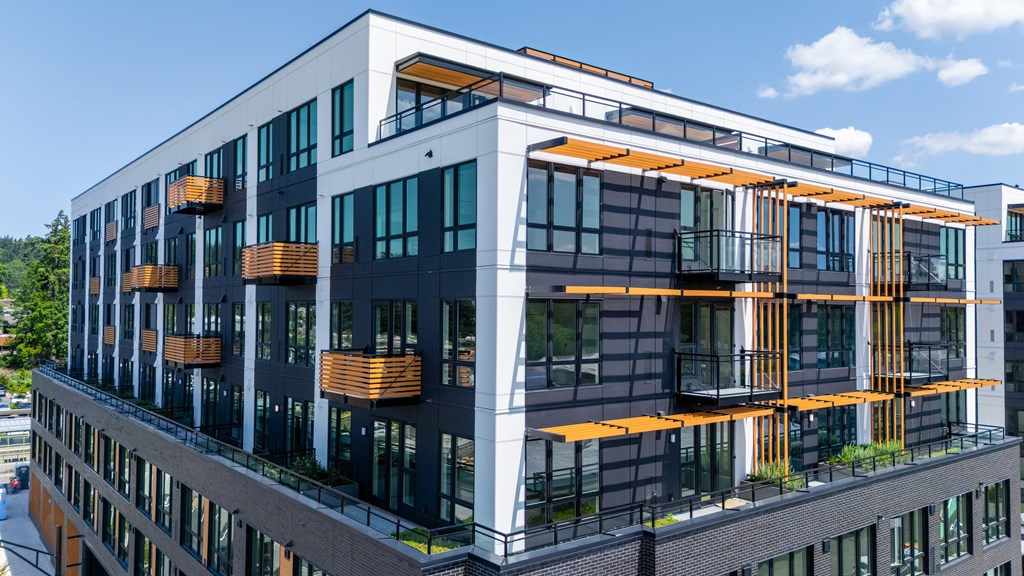 A modern building with a combination of black and white exterior and orange accents.