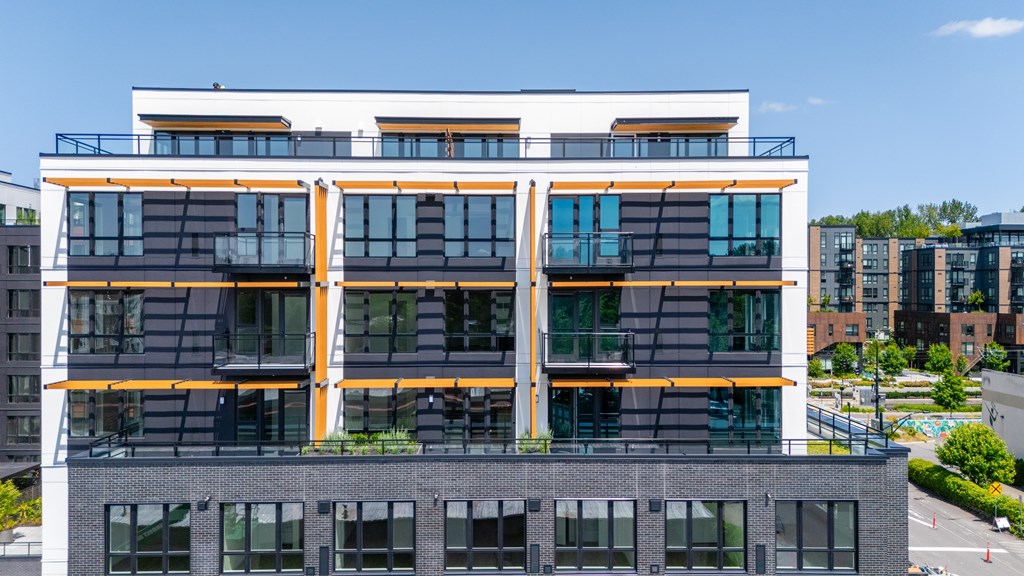 A modern building with a black and white facade and orange accents.