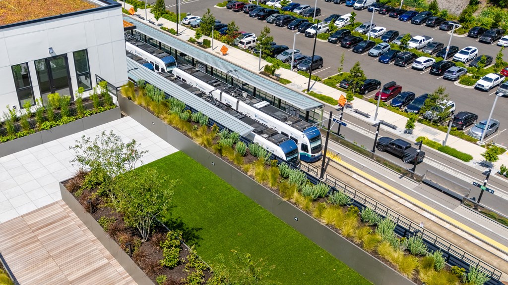 A parking lot with cars and a building with a green roof.