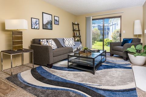 a living room with a couch coffee table and a sliding glass door Copper Ridge Apartments, Renton, 98055
