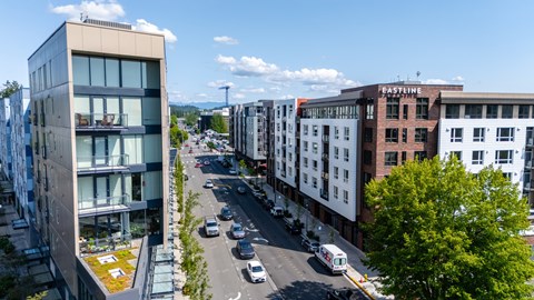 A city street with cars and buildings on either side.