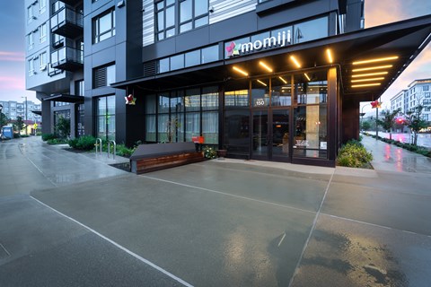 The image shows a modern building with the name "momiji" on it.