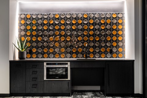 a wall of orange spheres is displayed on a black kitchen counter