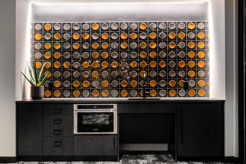 a wall of orange spheres is displayed on a black kitchen counter