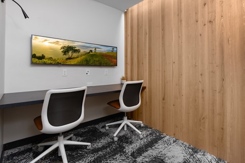 a conference room with two chairs and a painting on the wall