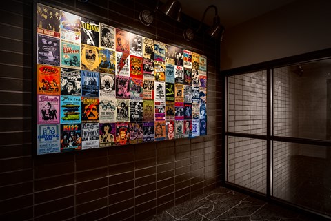 a wall of posters in a room with a glass door