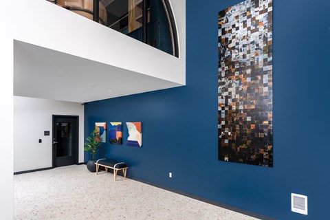 a hallway with a blue wall and a painting on the wall