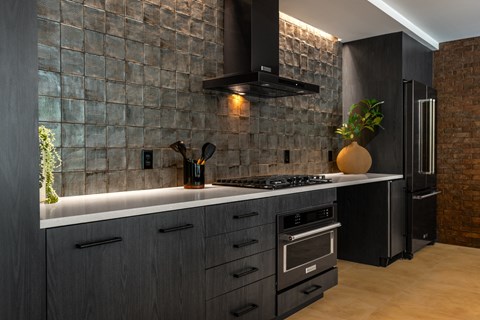 a kitchen with black cabinets and a counter top and a stove