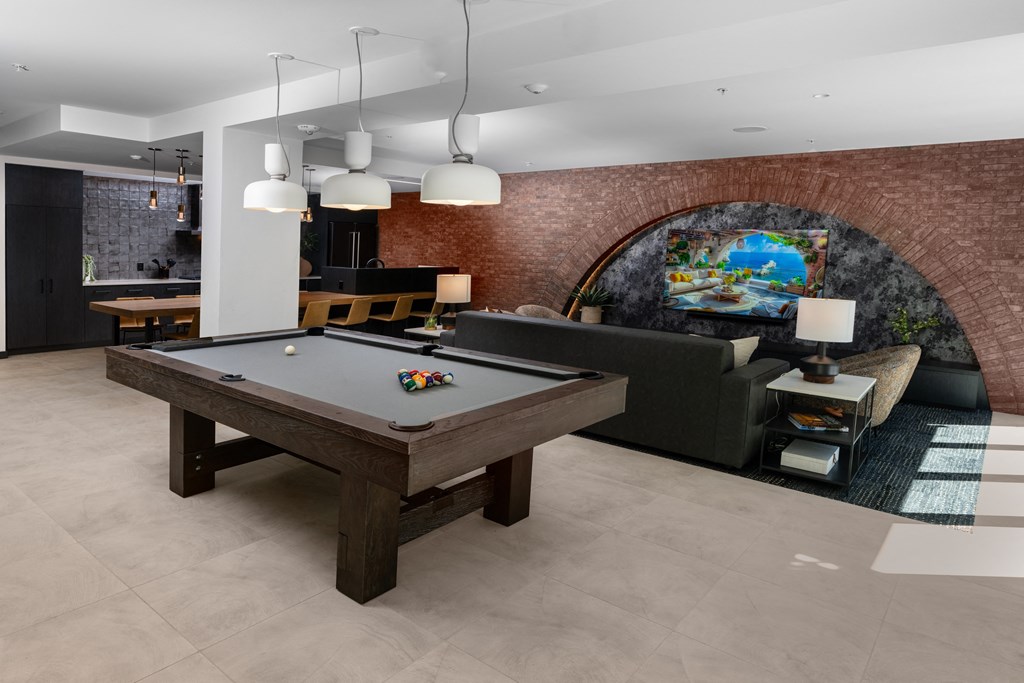 an open living room with a pool table in the center
