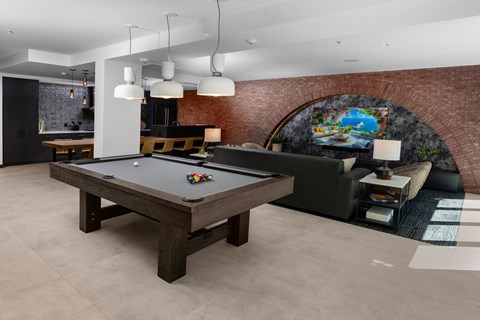 an open living room with a pool table in the center